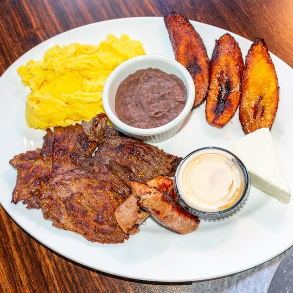 J's Brothers breakfast with scrambled eggs, steak, sausage, beans, plantains, and cheese.