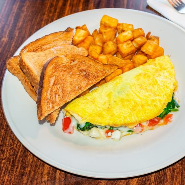 A J's Brothers breakfast plate with a cheese and vegetable omelet, home fries, and toast.